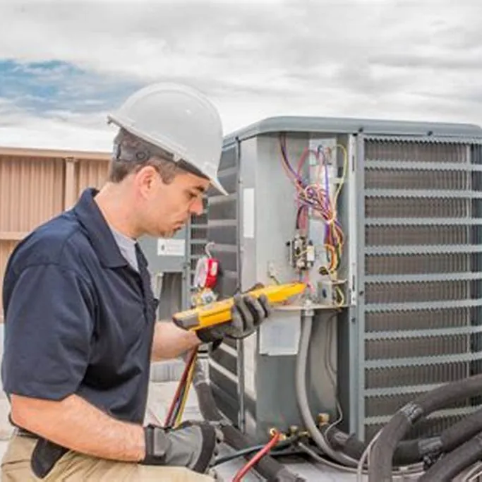 Technician testing an outdoor air conditioner with gauges