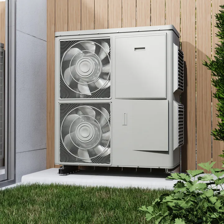 Twin-fan heat pump outdoor unit beside a wooden fence