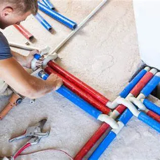 Plumber installing red and blue PEX water lines