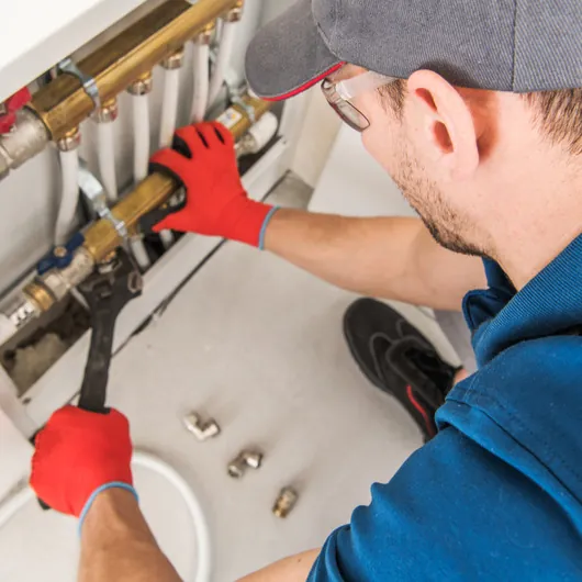 Plumber tightening a fitting on a water manifold