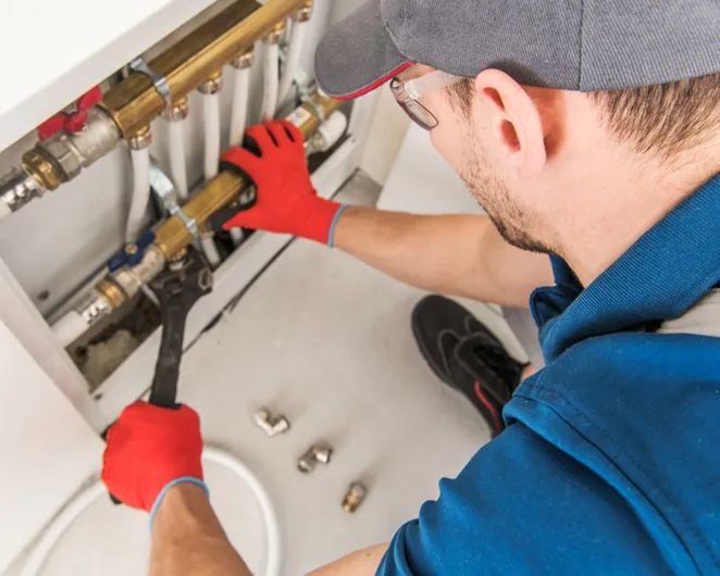 Plumber tightening a fitting on a water manifold