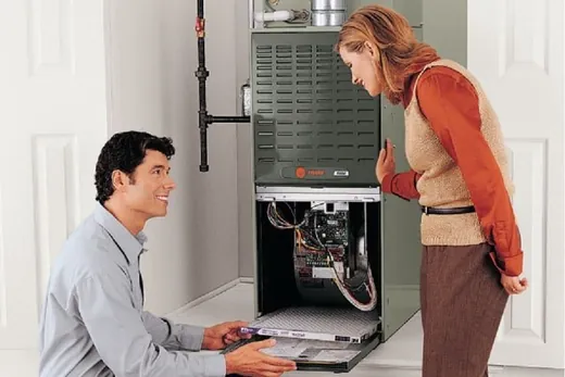 Technician showing a homeowner the inside of a furnace