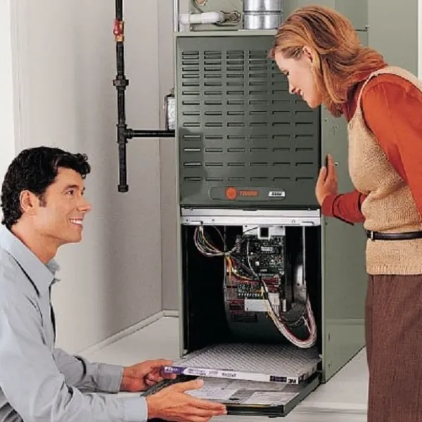 Technician showing a homeowner the inside of a furnace