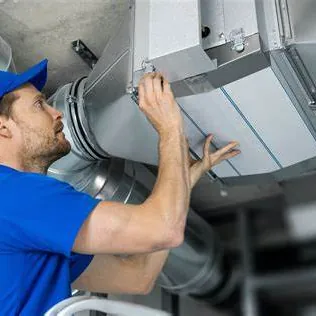 Technician inspecting overhead ductwork