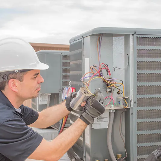 Technician checking the wiring inside an outdoor unit