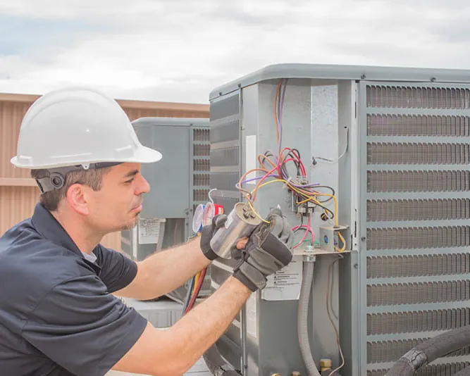Technician checking the wiring inside an outdoor unit