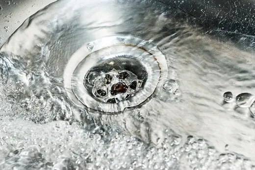 Water swirling down a stainless steel sink drain