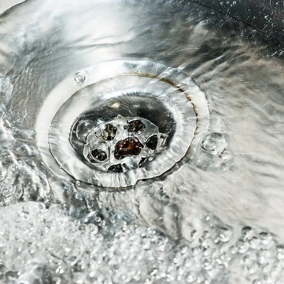 Water swirling down a stainless steel sink drain
