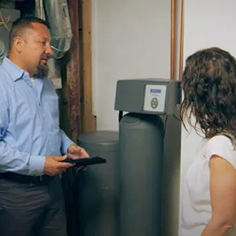 Technician explaining a water softener to a homeowner